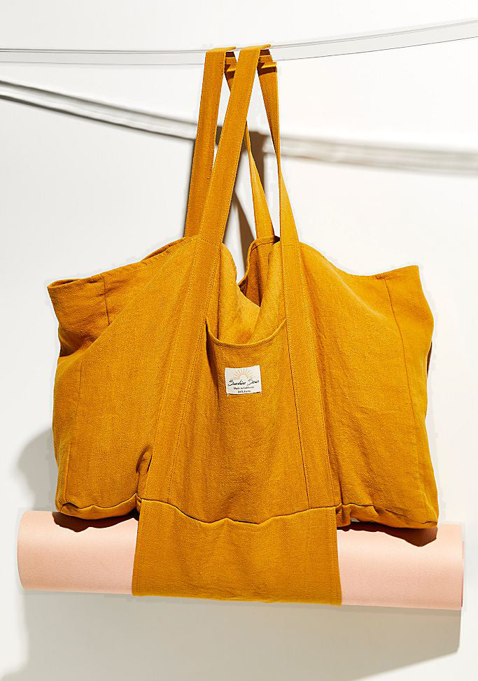 Turmeric Hemp Market Bag hanging with a rolled yoga mat